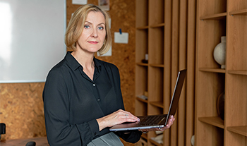 Confident professional woman with laptop, symbolising organisational culture change and leadership transformation.