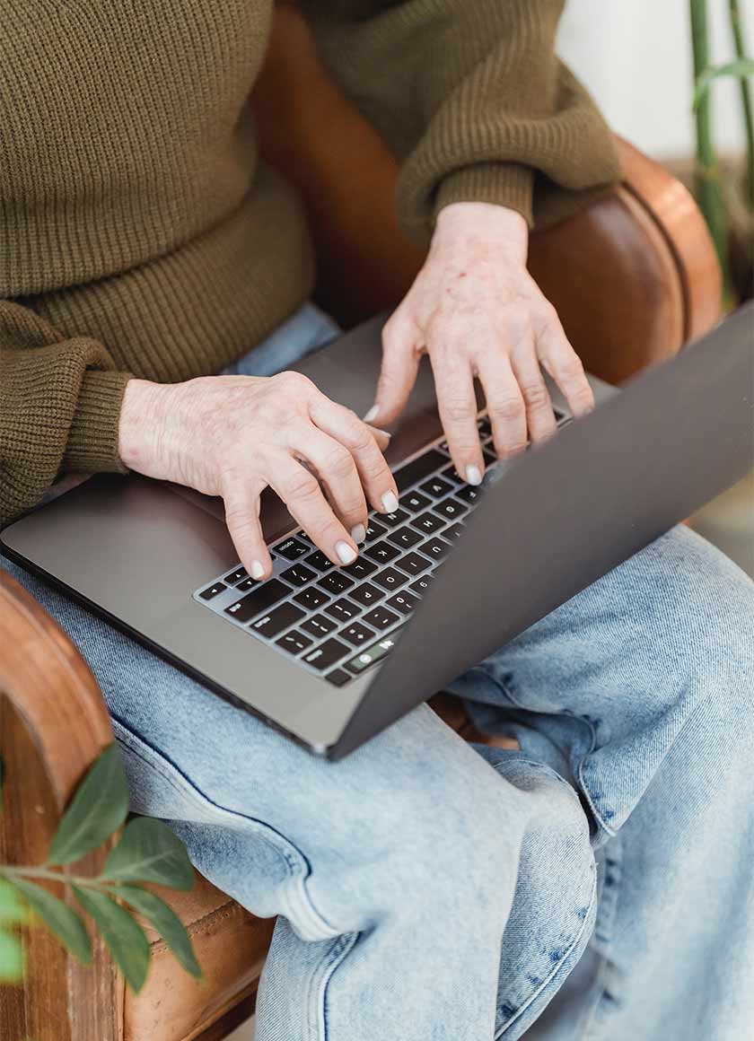 Close-up of hands typing on a laptop during online large group facilitation.