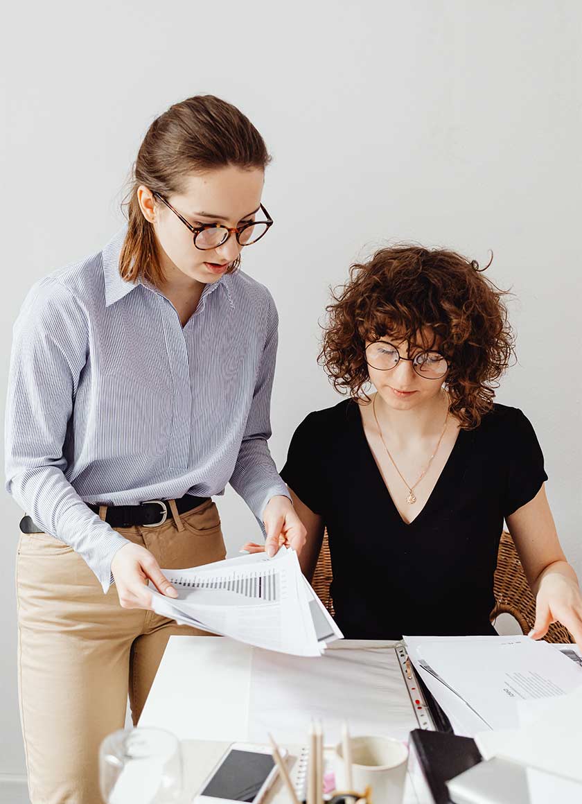 Two consultants reviewing strategy documents during a large group facilitation planning session.